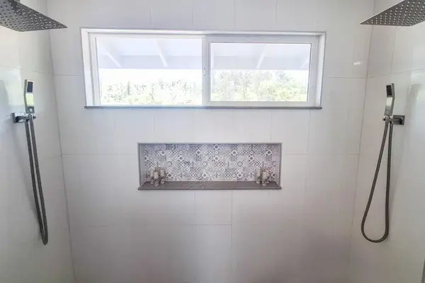 Master en-suite bathroom with double sinks and large walk-in shower with double shower heads.