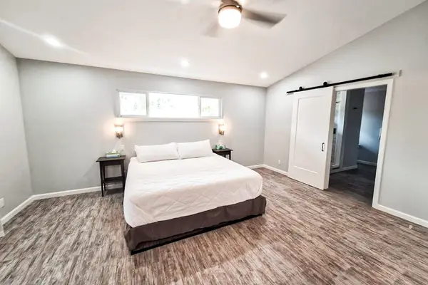 Large master bedroom with king bed and sliders to access the outside.