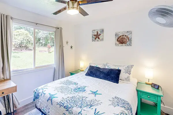Guest room with queen bed, ceiling fan and extra fan for your comfort.
