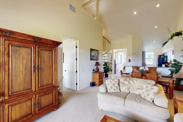 Open-Concept Living Area with Large Armoire & High Ceilings