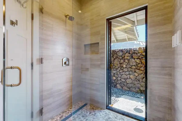 Walk-In Tile Shower with Glass Door & Access to Private Outdoor Space