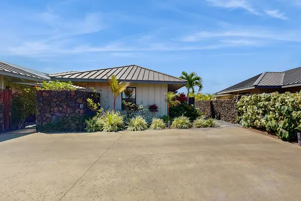 Front Exterior & Driveway Framed by Lava Rock Wall & Tropical Plants
