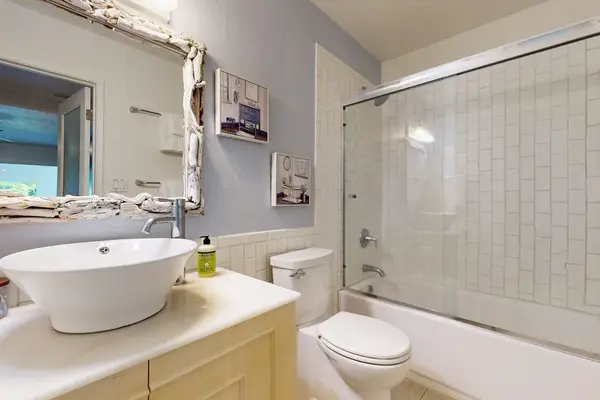 Full bathroom features vanity shower toilet and bright natural lighting