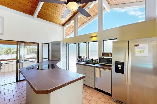 Kitchen island provides workspace appliances and bright outdoor views nearby