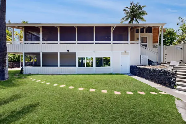 Landscaped lawn frames the home with palms and stepping stones
