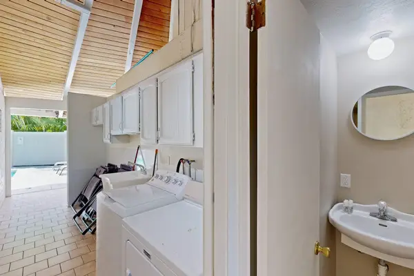 Bathroom sink and shower area feature mirror storage and tiled surfaces