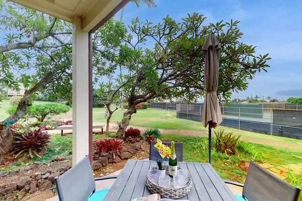Covered outdoor dining area surrounded by lush tropical landscaping