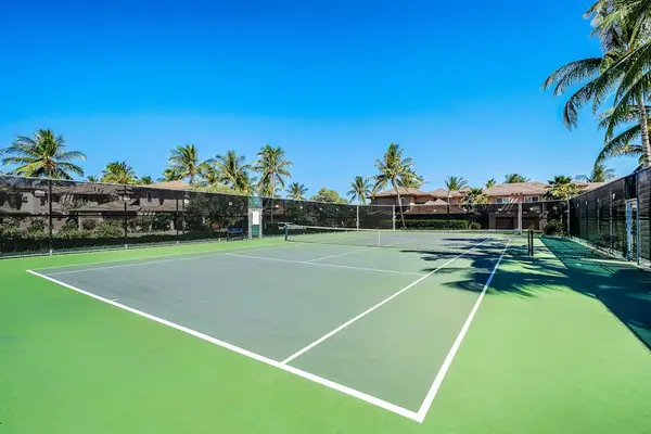 Championship Tennis Court Set Against Blue Tropical Skies