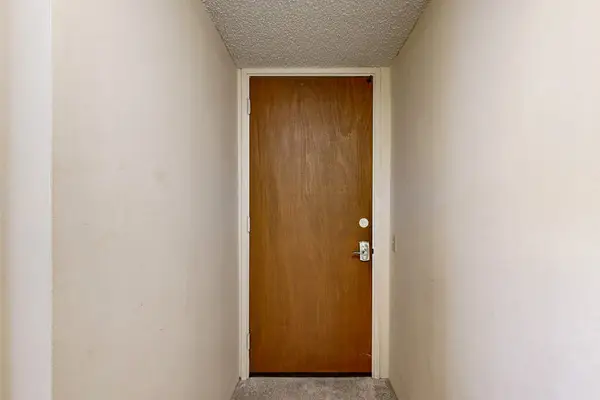A simple, private hallway leads to the secure wooden entry door of your vacation.