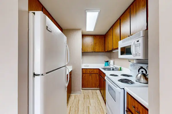 Fully equipped kitchen with a full-size refrigerator, stove, microwave, and ample cabinet storage for convenient meal preparation.
