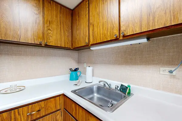 The kitchen prep station includes ample countertop space and a stainless steel sink for convenient cleanup after dining in.