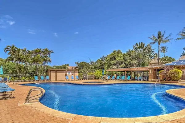 Resort pool offers refreshing water, sunny seating, tropical surroundings