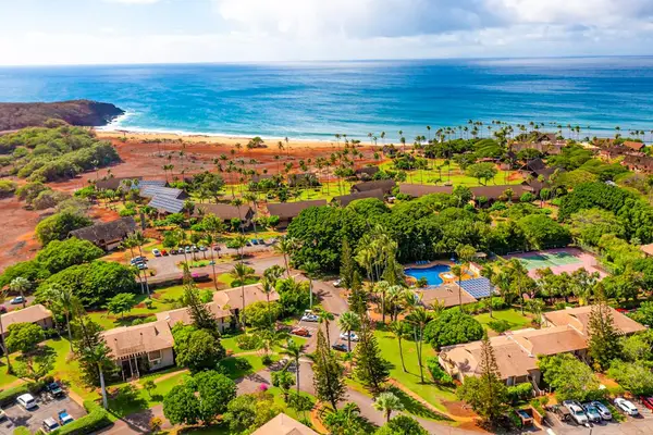 Aerial coastline panorama reveals island neighborhoods beside blue Pacific waters