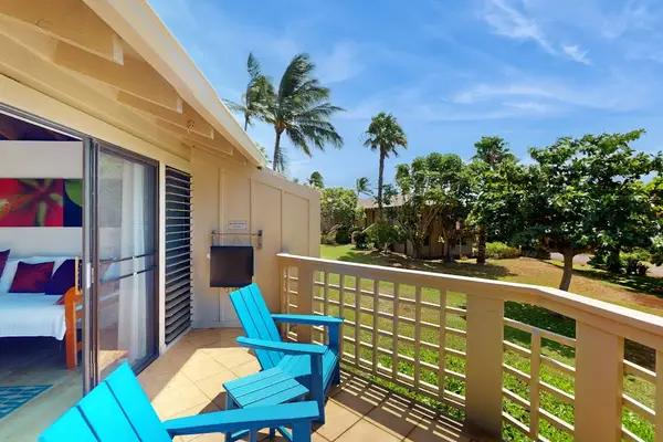 Balcony chairs overlook tropical greenery with refreshing island breezes outside
