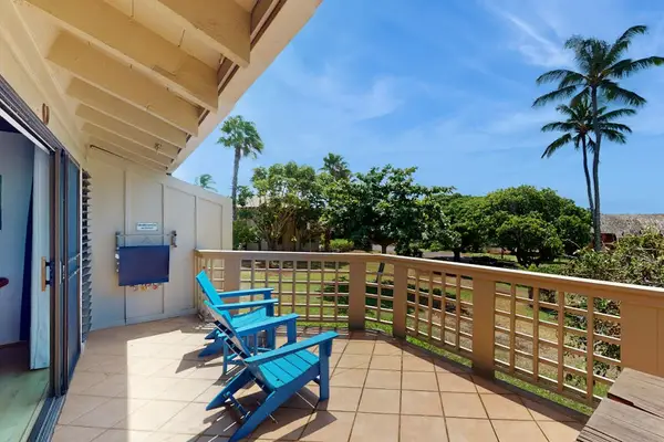 Sunlit balcony offers comfortable chairs and refreshing tropical surroundings outside