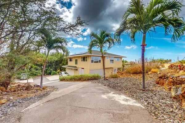 Island home exterior offers convenient parking and welcoming tropical surroundings