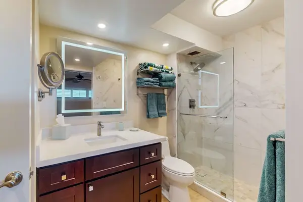 Bright, updated bathroom featuring a spacious tiled walk-in shower and modern finishes.