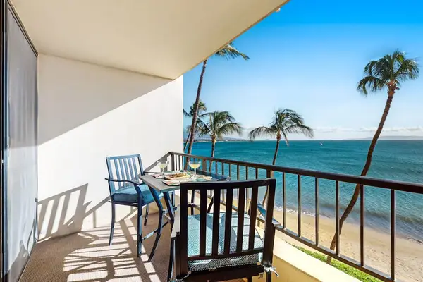 Private lanai with comfortable seating, perfect for relaxing while enjoying beach views and swaying palm trees.