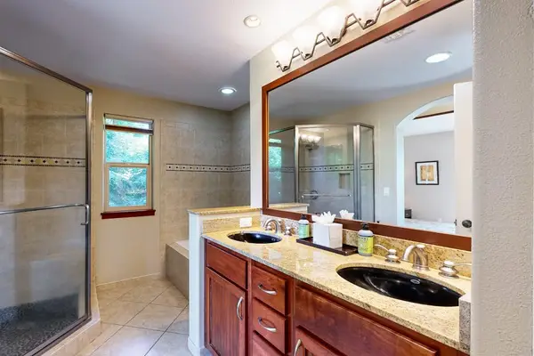 Master bathroom with two sinks and a large walk in shower.
