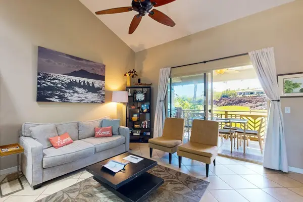 Living room with vaulted ceilings and large screen door for fresh air and natural light.