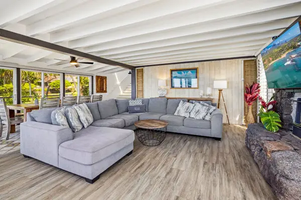 Large living room with sofa bed, flat screen tv and lots of natural light.