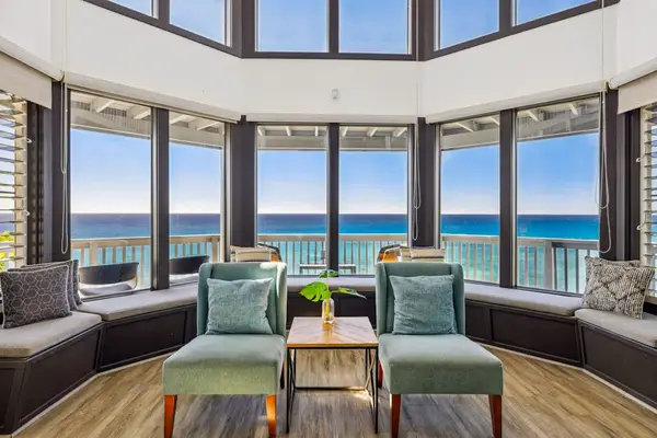 Spacious living room with panoramic views thanks to all of the glorious windows.