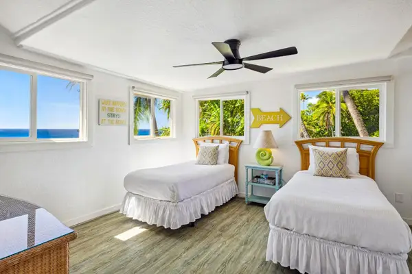 Guest room with two twin beds and a ceiling fan.