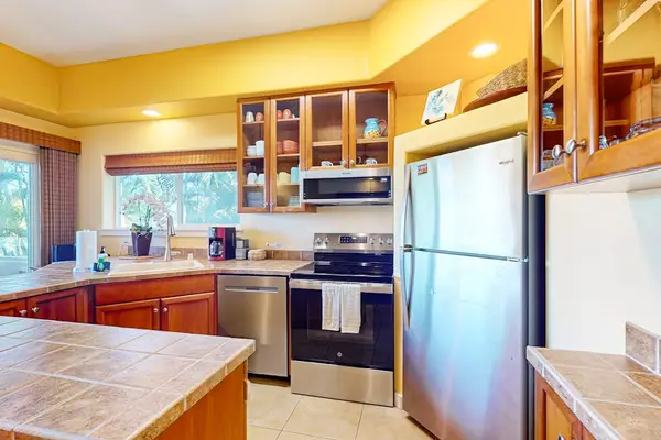 Kitchen Area with Full-Sized Refrigerator, Range Oven, Built-In Microwave, and Cabinet Space