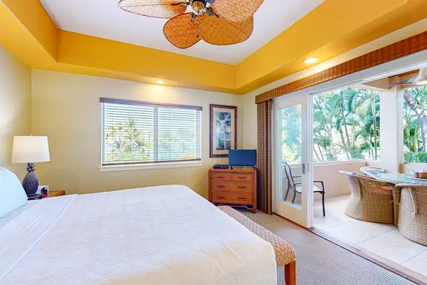 Bright Bedroom Suite Featuring Sliding Glass Doors to Balcony, King Bed, and Tray Ceiling