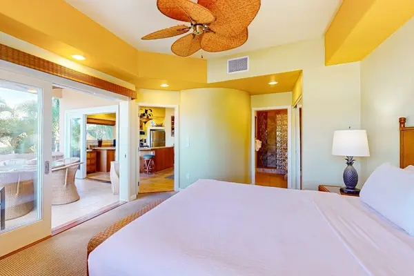 Spacious Bedroom with Direct Balcony Access, Ceiling Fan, and Bedside Lamp