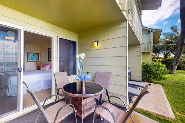 Private lanai with outdoor seating overlooking the tropical grounds.
