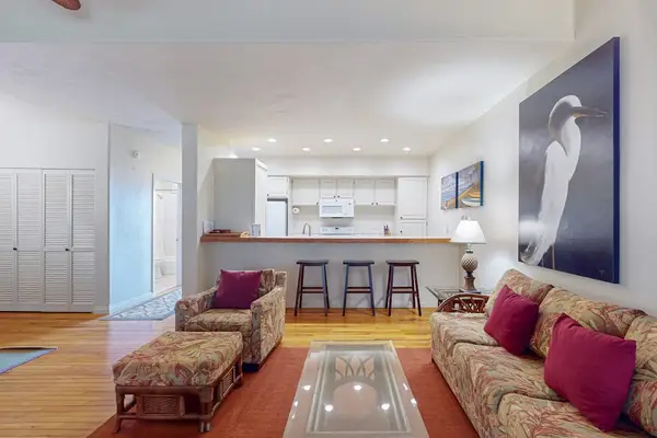 Spacious living room welcomes abundant daylight through impressive glass walls and open design