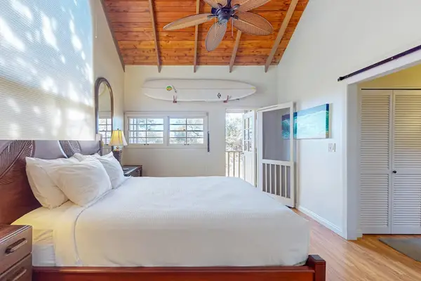 Bright bedroom offers a comfortable bed natural light and tropical decor