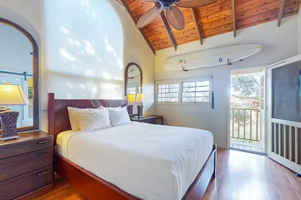Cozy bedroom includes a queen bed dresser and bright tropical views