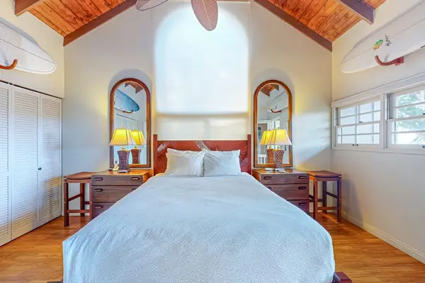 Inviting bedroom showcases a queen bed matching dressers and island charm