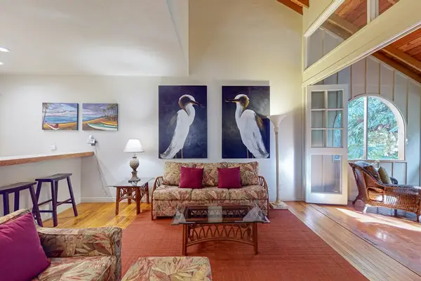Open living room features expansive glass walls creating bright inviting indoor surroundings throughout