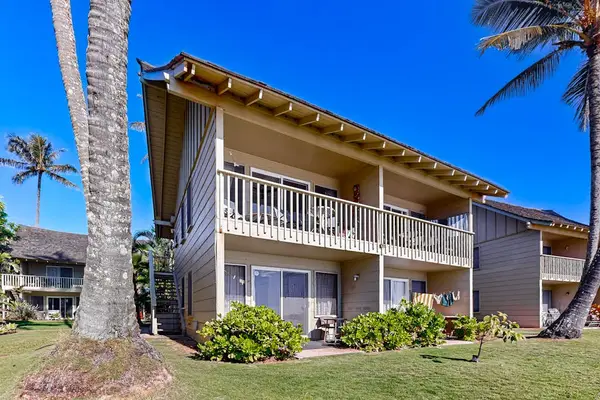 Charming oceanfront building surrounded by tropical landscaping.