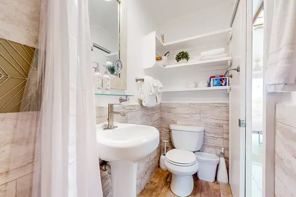 Compact full bathroom with a walk-in shower and essential amenities.
