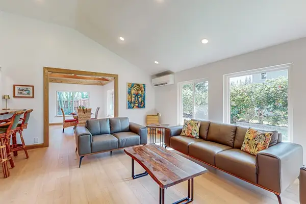 Bright living room offers comfortable seating dining access and garden views