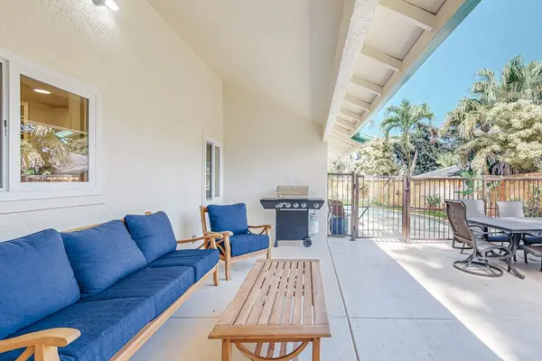 Covered patio offers blue seating outdoor table and tropical breezes
