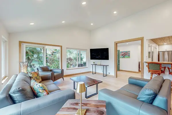 Spacious living room pairs plush sofas with television and garden outlook