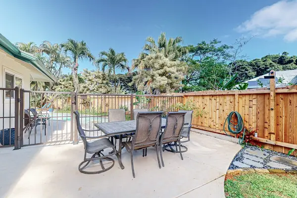 Sunny patio dining area overlooks palms with comfortable outdoor seating