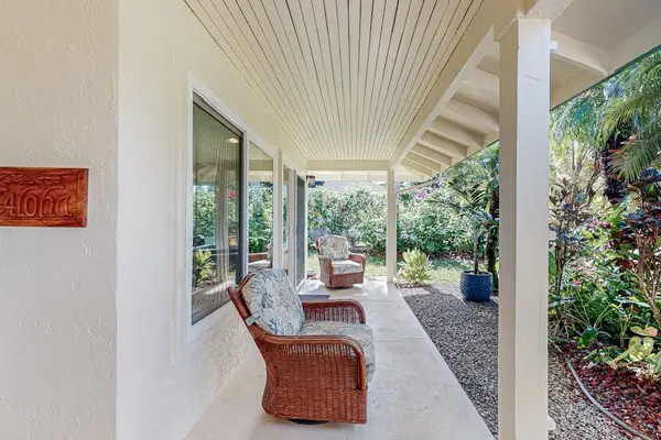 Covered lanai offers wicker seating garden views and gentle island breezes