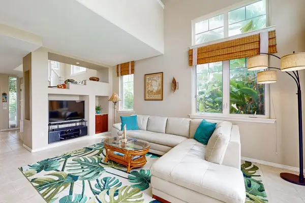 Living room offers comfortable seating natural light and tropical views