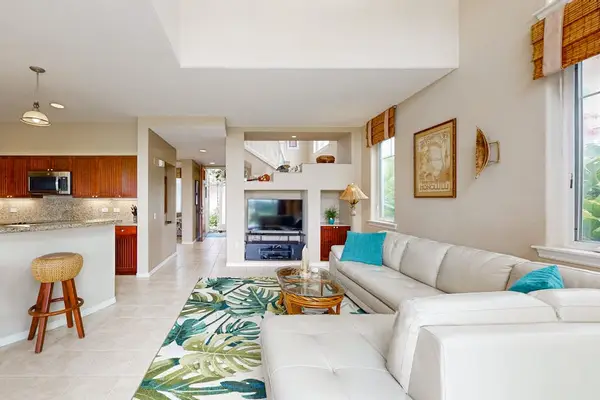 Living room includes sofa seating television and connected kitchen area
