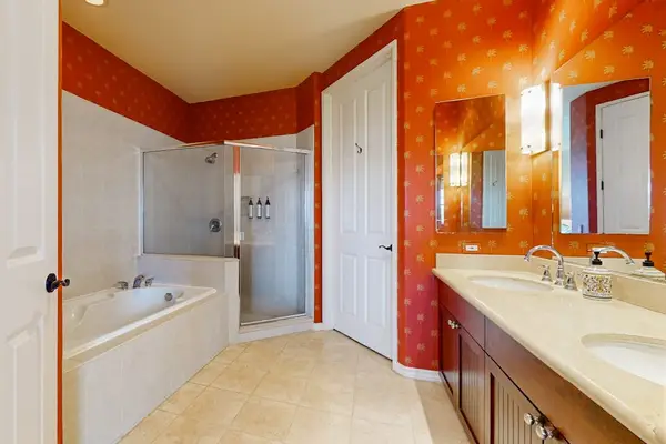Bathroom offers bathtub vanity mirror and colorful patterned shower curtain