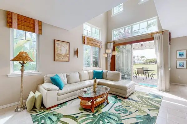 Living room opens toward windows with comfortable seating and artwork