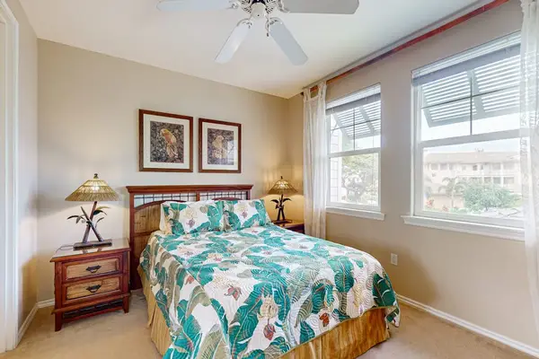 Bedroom offers inviting bedding ceiling fan and natural garden light