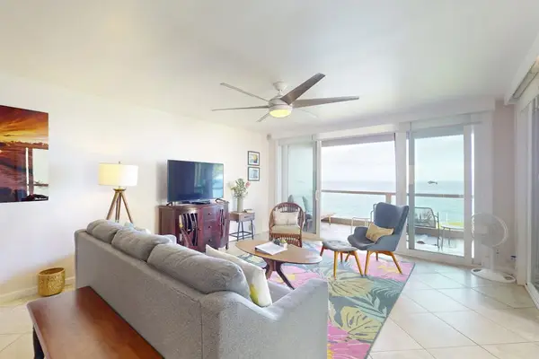 Spacious Living Room with Comfortable Sofa, Ceiling Fan, Flat-Screen TV, and Sliding Glass Doors