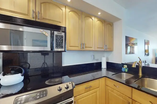 Fully Equipped Kitchen with Over-the-Range Microwave, Electric Stovetop, and Wooden Cabinetry